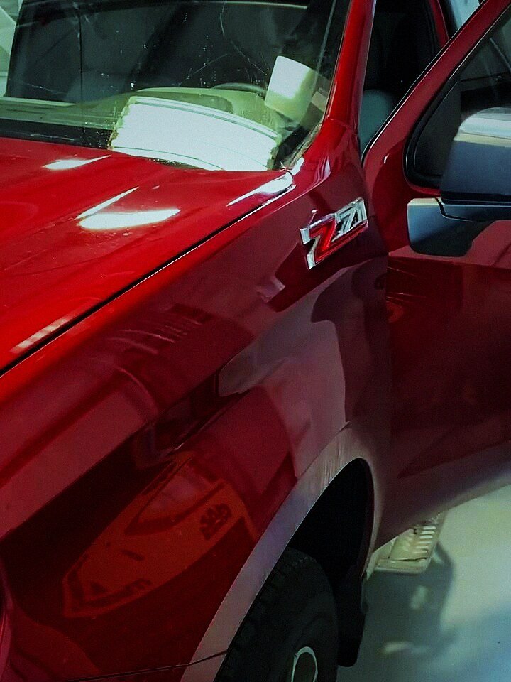 Red Chevy Silverado Z71 in the bay for rear glass