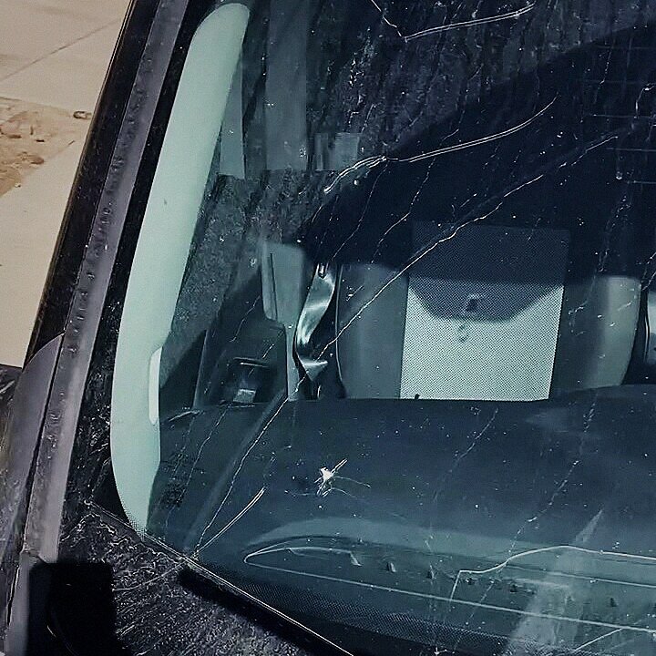 Impact chip and crack across a work van windshield