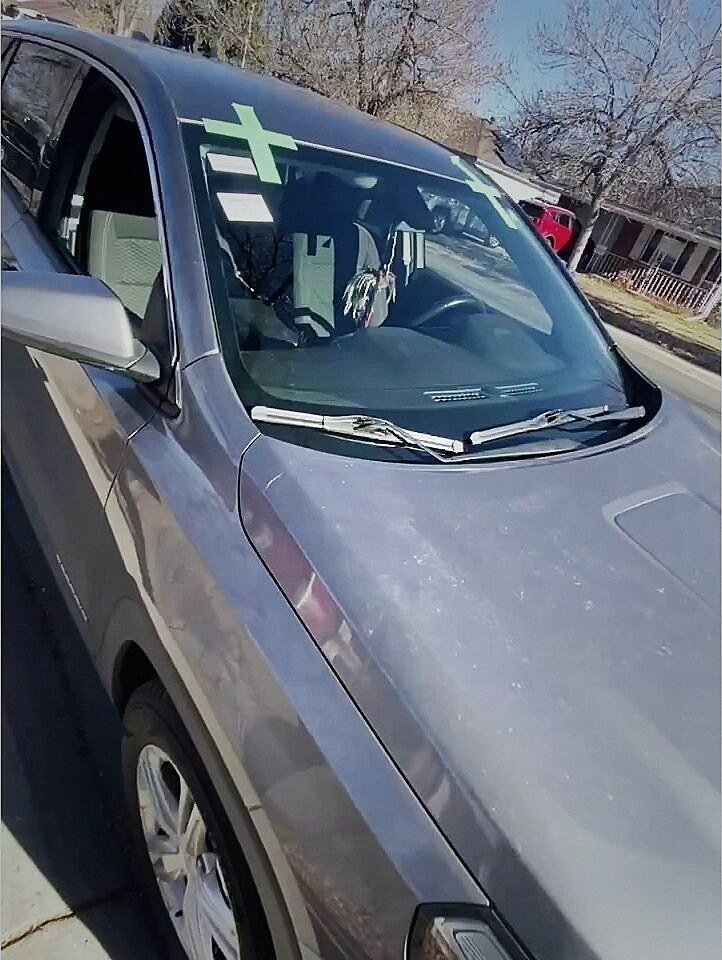 Chevy Equinox with green retention tape crosses on a new windshield