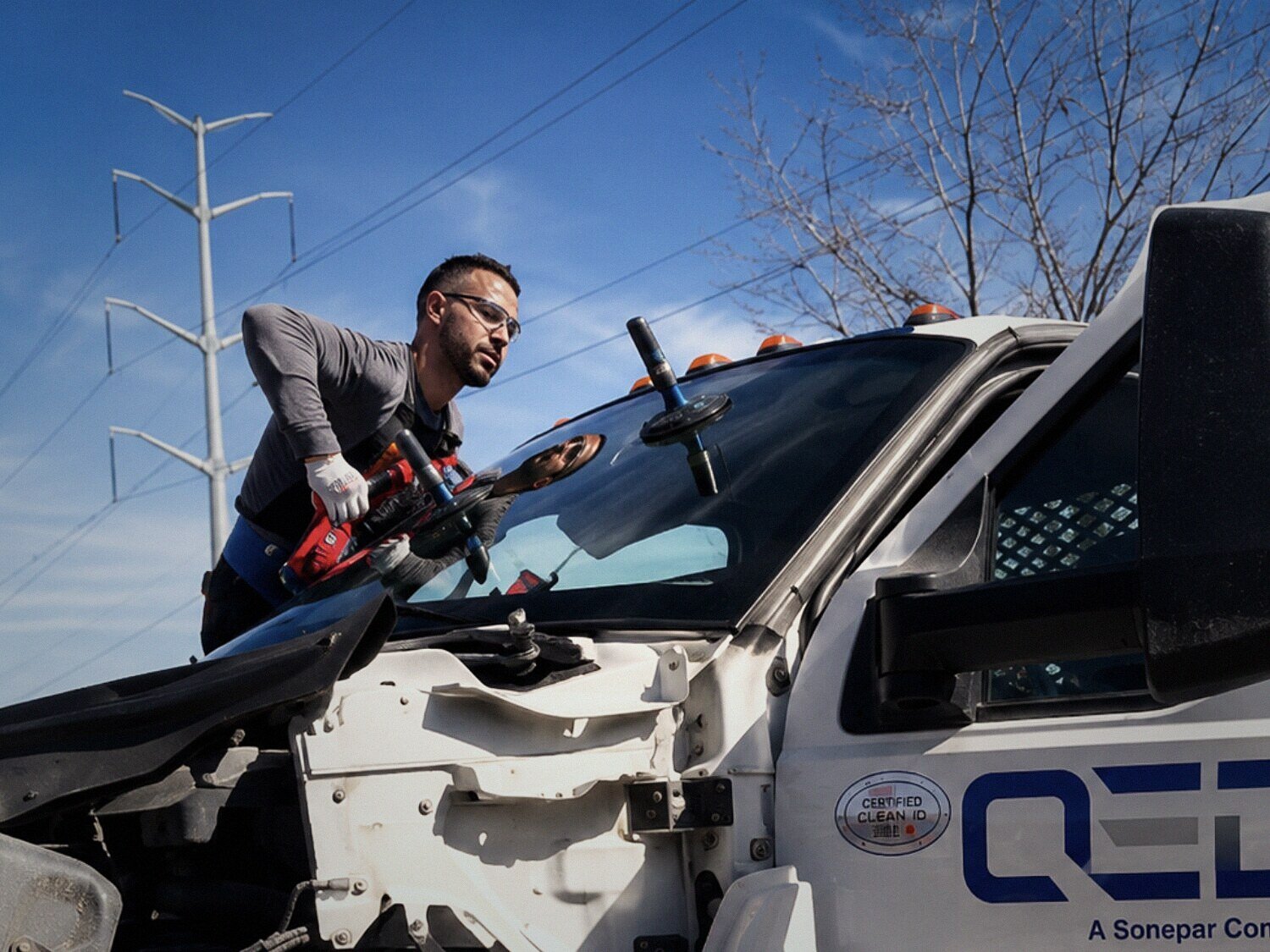 Technician replacing the windshield on a commercial fleet truck on site